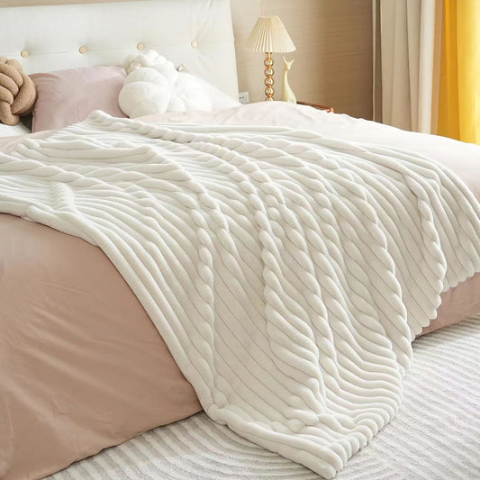Ivory ribbed faux fur blanket draped over a bed